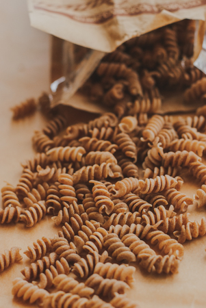 wholemeal pasta fusilli from organic whole grain spelt falling from a paper bagの写真素材