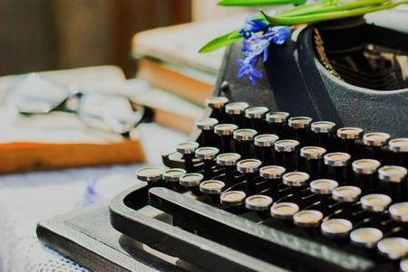Vintage typewriter and old books on table