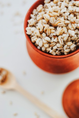 Barley porridge in a clay bowl on white backgroundの写真素材