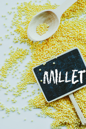 organic millet seeds and chalkboard with word millet on white backgroundの写真素材