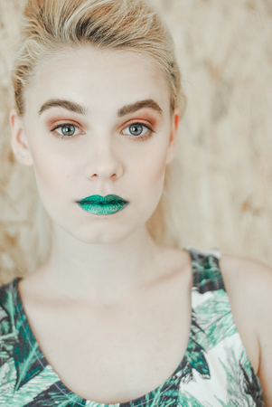 Fashion portrait of Young blond woman.Beautiful Girl with green lipsの写真素材