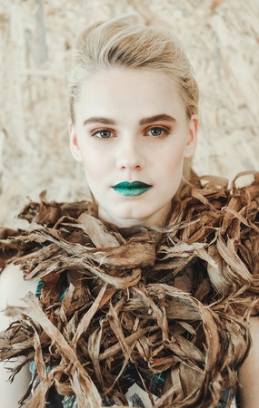 Fashion portrait of Young blond woman.Beautiful Girl with green lips. Concept Mother Nature