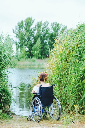 woman in a wheelchair, enjoying time outdoorの写真素材