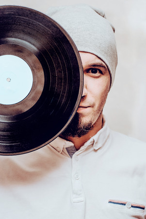 cool stylish man wearing hat with vinyl recordの写真素材