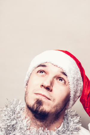 Young handsome brunette man wearing red hat, happy, on white background with copy space, looking upの写真素材