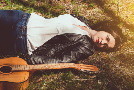 woman playing an acoustic guitar outdoorの写真素材