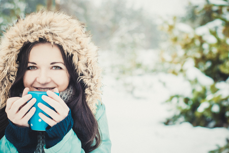 Woman with big mug of hot drink during cold day.の写真素材
