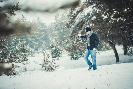 A young man throwing a snowball in the forestの写真素材