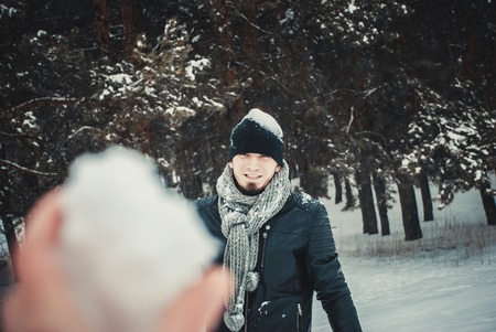 A young man throwing a snowball in the forestの写真素材