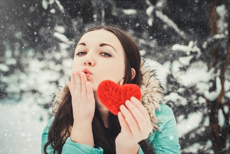 Young woman outdoor holding red knitted heart