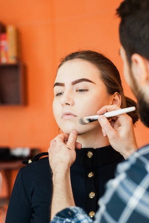 Make-up artist doing make-up of a beautiful young girlの写真素材