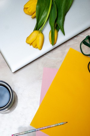 Stylish flat lay home office desk workspace with laptopTop view lifestyle blog. Flat lay, Bunch of spring tulip flower.A bouquet of spring flowers with laptop. Spring Tulips Background. Mothers day.の写真素材