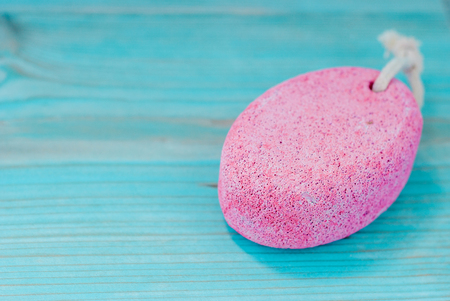 Natural pumice stone with white rope on wooden background. Pedicure and spa concept.の写真素材