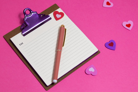 Womens pink office desk. Notepad, pen, stickers on a pink background. Flat lay, top view, copy space, bannerの写真素材