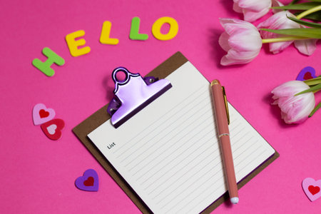 Composition with blank notebook, word Hello and beautiful tulip flowers on pink backgroundの写真素材