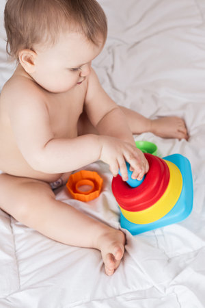 Cute baby playing with colorful rainbow toy pyramid. Toys for little kids.の写真素材