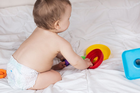Cute baby playing with colorful rainbow toy pyramid. Toys for little kids.の写真素材