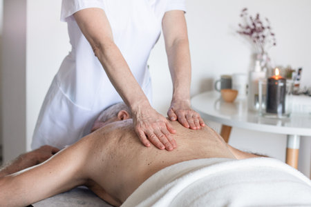 Man receiving back massage from masseur in spaの写真素材