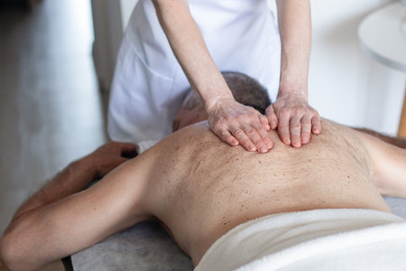 Man receiving back massage from masseur in spaの写真素材