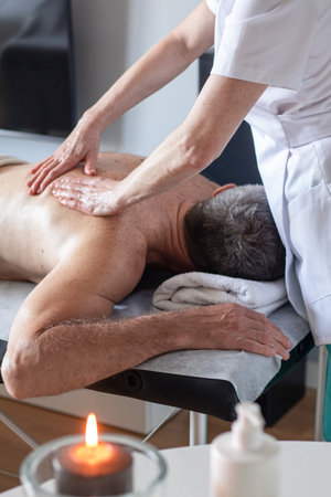 Man receiving back massage from masseur in spaの写真素材