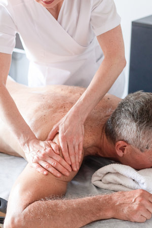 Man receiving back massage from masseur in spaの写真素材