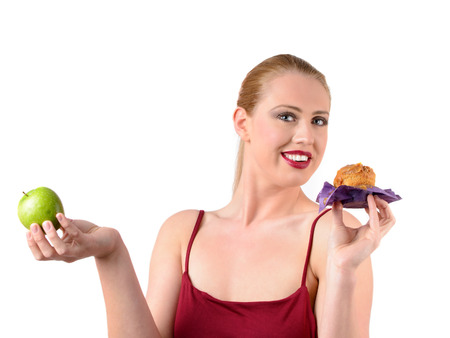young woman choosing cake or fruitの写真素材