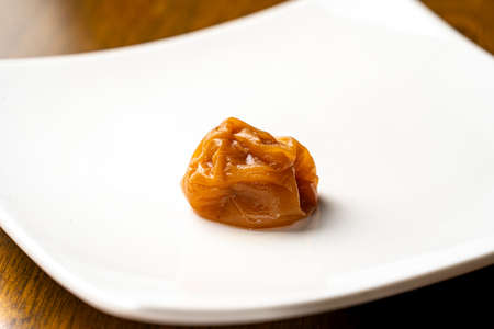 There is a umeboshi on a white plate.の写真素材