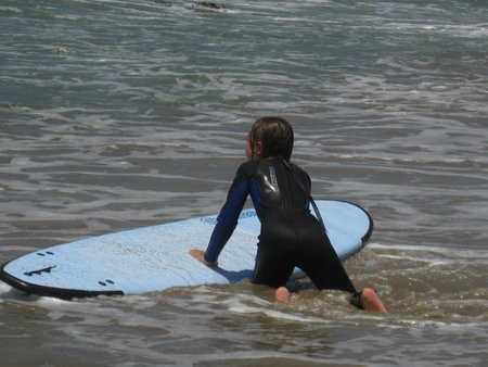 Girl in Wet Suit on Blue Surfboard in Water