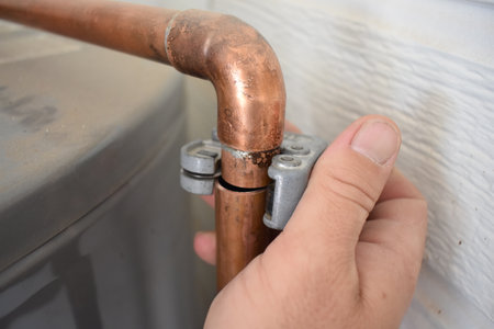 Hand Cutting a Copper Pipe while Installing a Water Heater