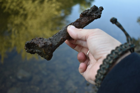 Fingers Holding Old Rusty and Crusty Railroad Tie by Riverの写真素材