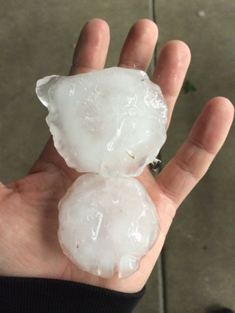 Human Hand Holding Two Giant Pieces of Hail