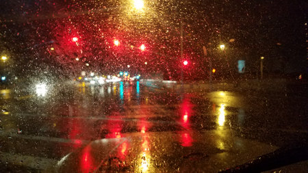 Driving in the Rain at Night, Wet Windshield and Blurry Lightsの写真素材