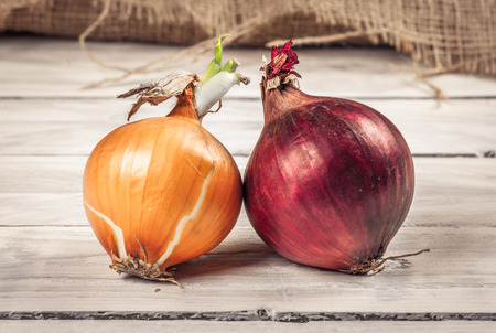 Red and white onions on a wooden tableの写真素材