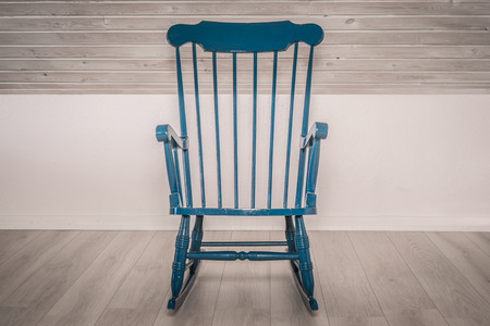 Blue rocking chair on a wooden floorの写真素材