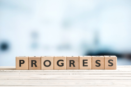 Progress word spelled with wooden cubes on a deskの写真素材