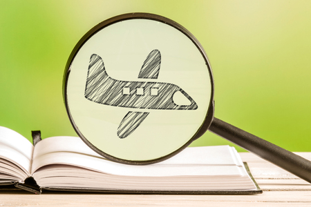 Travel information with a pencil drawing of an airplane in a magnifying glassの写真素材
