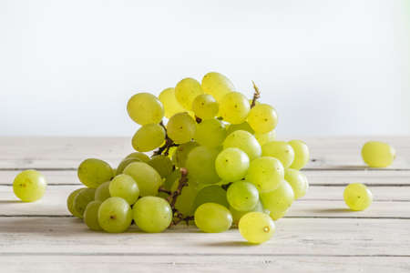 Green vine grapes on a wooden kitchen table