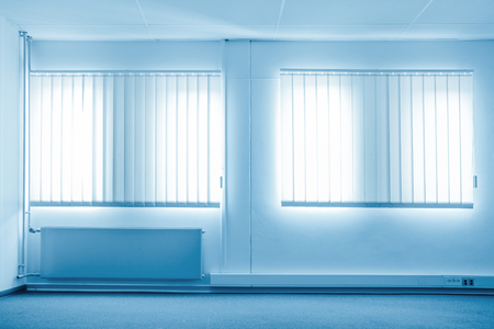 Sunshine coming through windows in a blue roomの写真素材