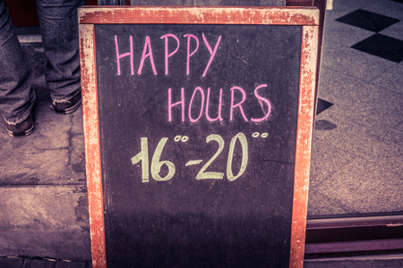 Happy hour board with text written in chalkの写真素材