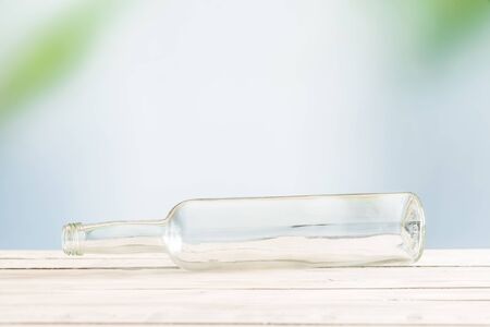 Glass bottle on a wooden table in a tropical environmentの写真素材