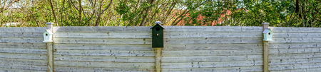 Bird houses on a row in a garden in panoramaの写真素材