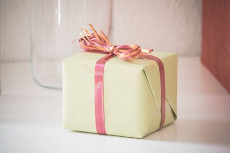 Package with colorful ribbon on a white desk