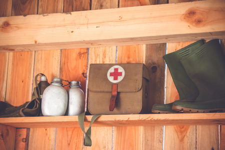 Retro medic equipment on an old wooden shelfe with boots and water bottlesの写真素材