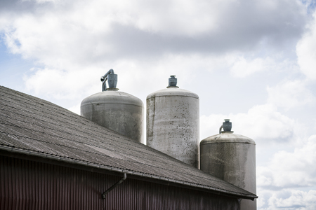 Silos in a dirty grunge look by a barn in a rural environmentの写真素材