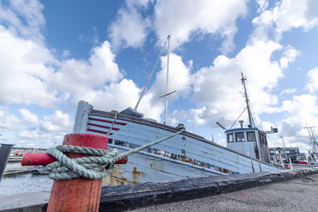 Fishing boat in a Scandinavian harbor in retro blue colors under a blue skyの写真素材