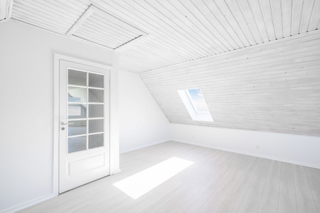 Bright room with the sun shining through a small window in a wooden apartment with a glass doorの写真素材