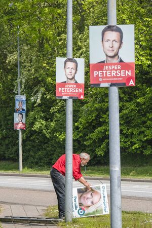 HADERSLEV, DENMARK - MAY 15 - 2019: Senior citizen hanging up political posters for the goverment election in Denmark.のeditorial素材