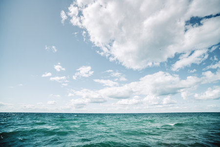 Turquoise water in a cold nordic sea under a blue sky with white clouds
