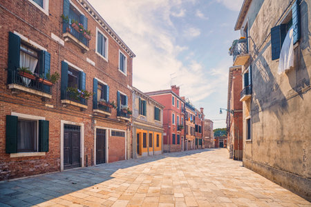 Italian street with colorful buildings in Venice in the summer with a tiled streetの写真素材