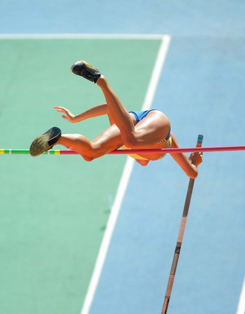 An athlete attempts successfull a pole vaultの写真素材